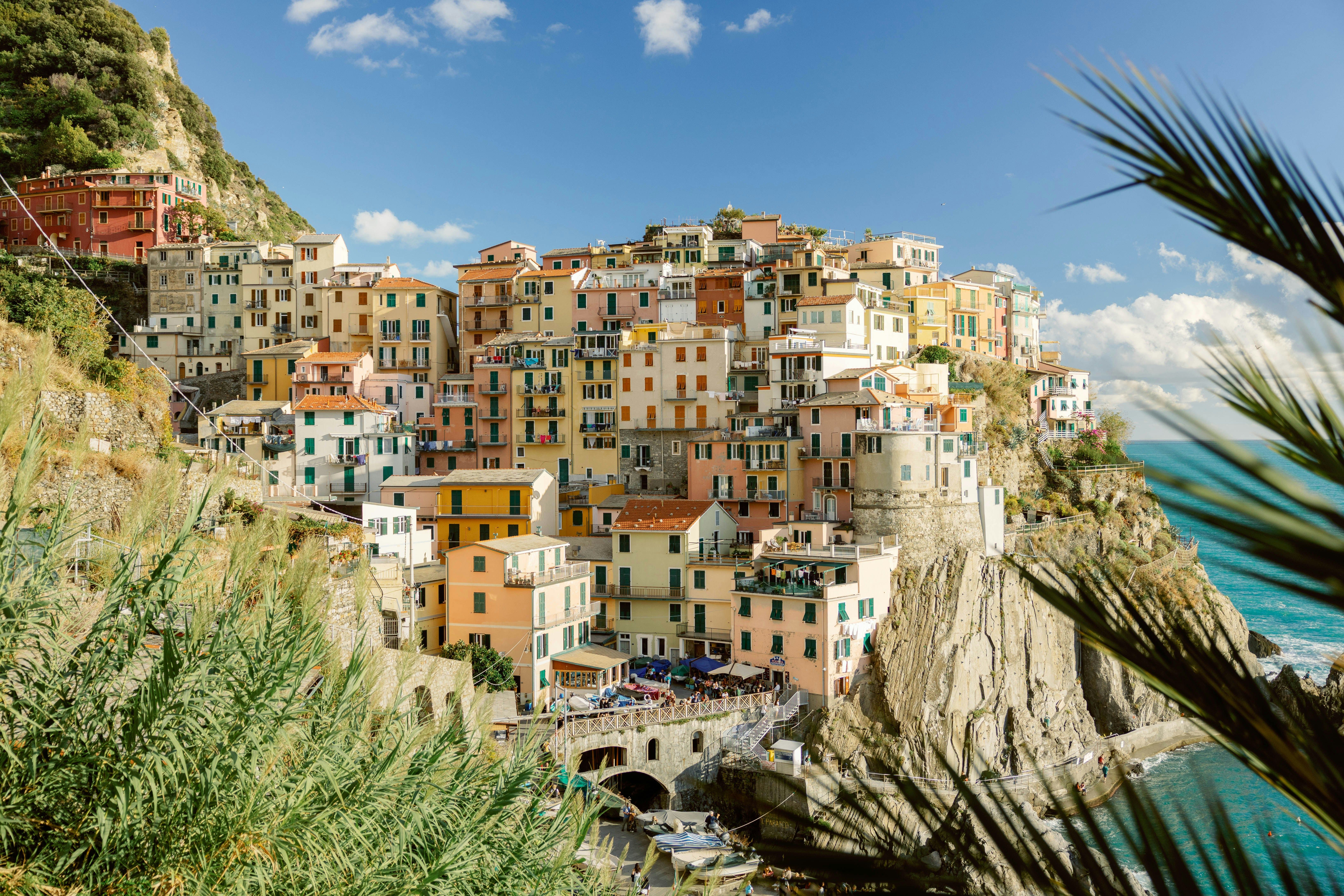 Colorful cliffside village overlooking the turquoise sea under a clear blue sky.